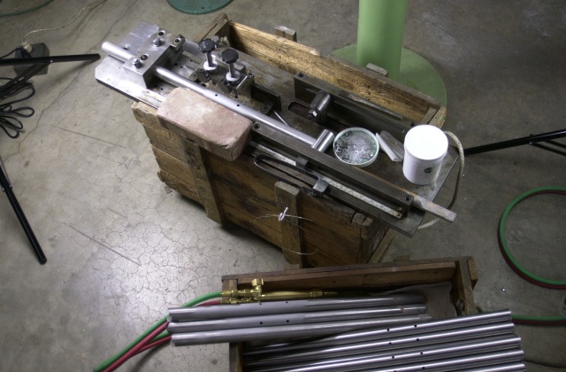 Fixture which for once and all ends water bottle boss diamond float.  Tube mitre fixture is mounted with water bottle boss brazing jig and set atop a 1970's vintage Prugnat lug shipping crate.  Seat tubes in lower right of pic have been drilled and sand blasted and are ready for brazing.