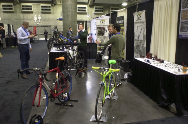 2016 Reynolds Technology Ltd. booth at NAHBS.  Strawberry red/white road bike in foreground.